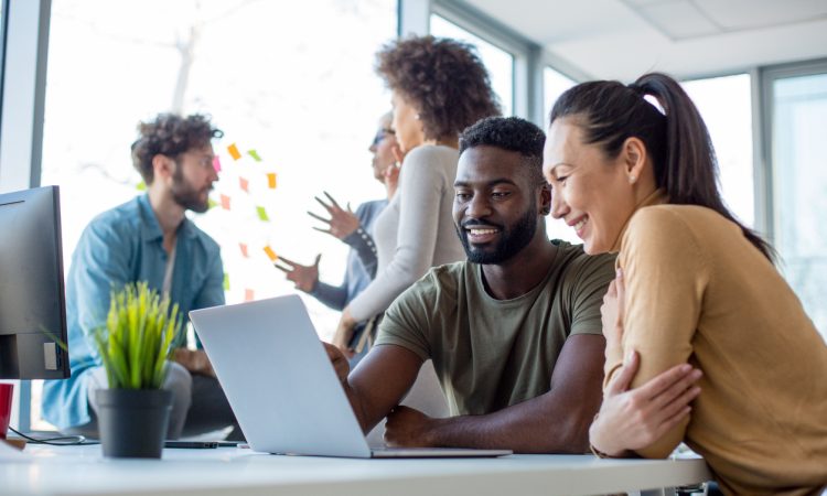 People talking in groups in office