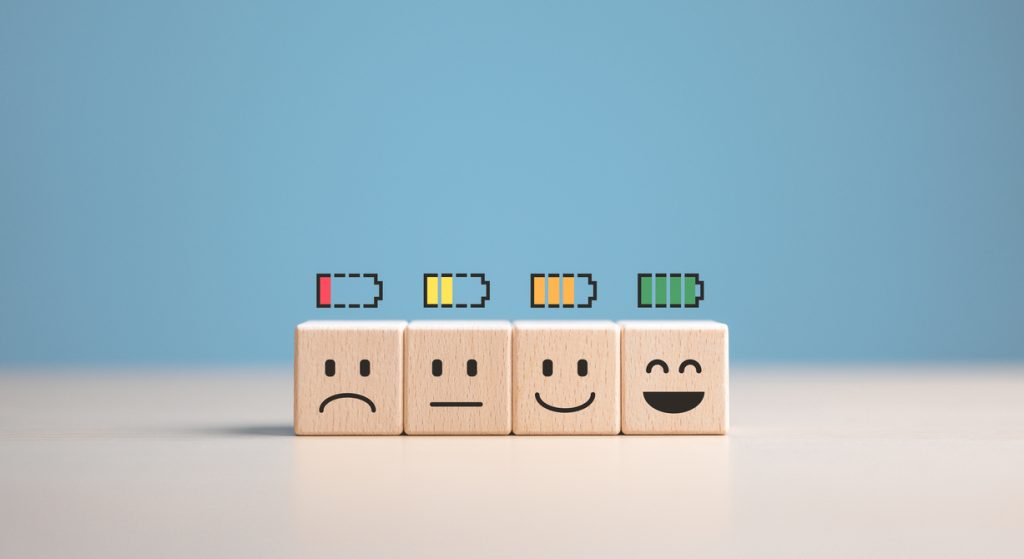 Percent of battery level from sadness to smiley face on wooden cubes