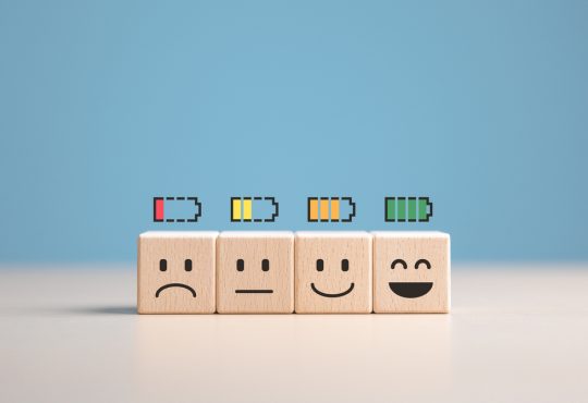Percent of battery level from sadness to smiley face on wooden cubes
