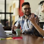 Two people sitting and talking at work.