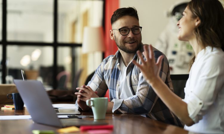 Two people sitting and talking at work.