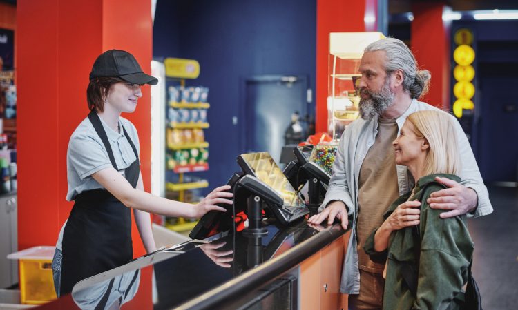 Teen cashier working at movie theatre