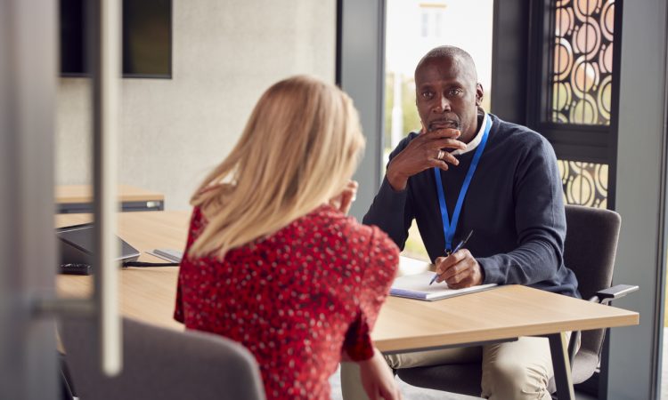 Two people sitting across table and talking