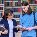 female teacher helping male student.