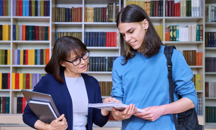 female teacher helping male student.