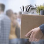 Person carrying box filled with office items