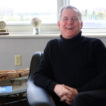 Rob Shea sits in an armchair smiling during interview