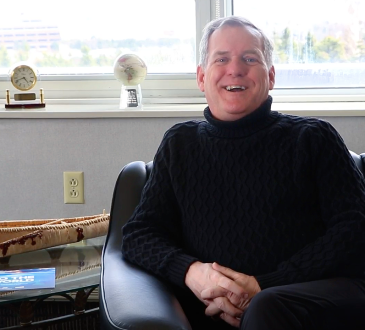 Rob Shea sits in an armchair smiling during interview