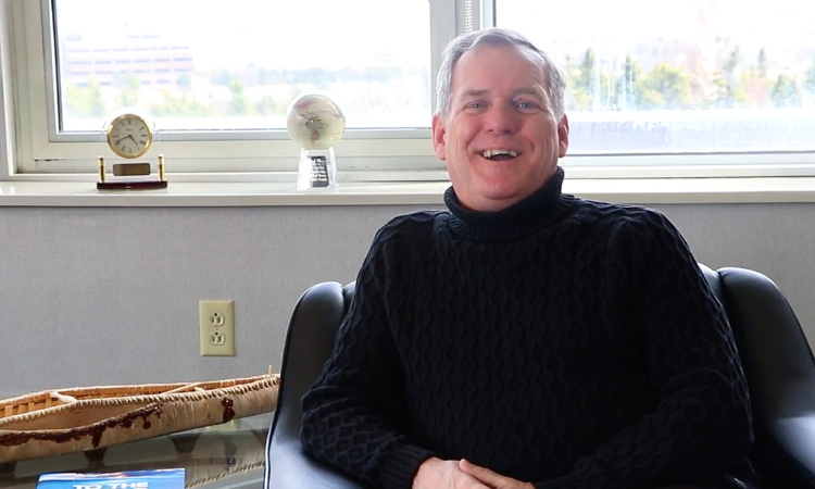 Rob Shea sits in an armchair smiling during interview