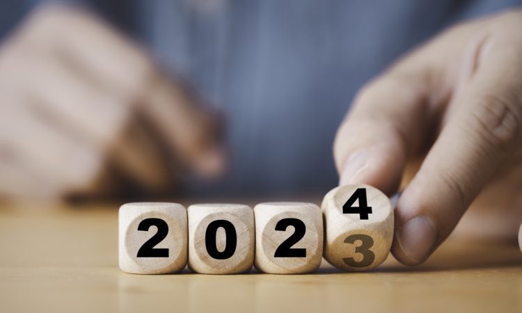 Hand flipping of 2023 to 2024 on wooden block cube.