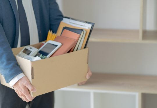 Man holding a box with several items.