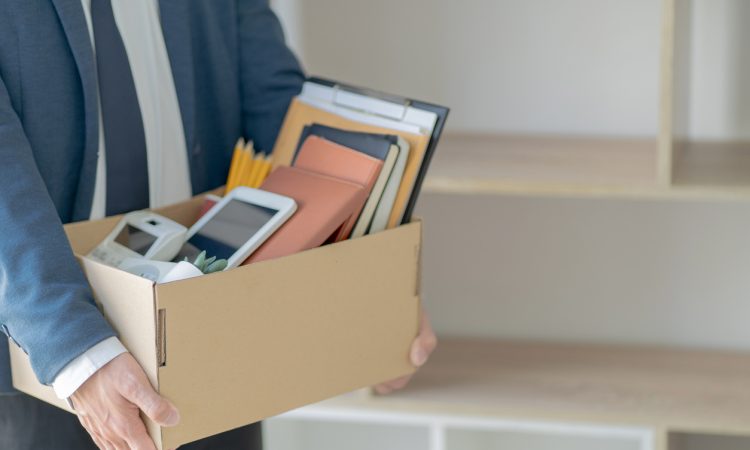 Man holding a box with several items.