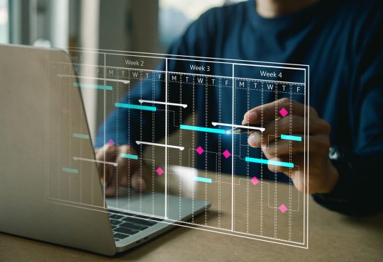 The image shows a person working on a laptop with a transparent digital overlay displaying a project timeline or Gantt chart, illustrating weeks of planned tasks and deadlines.