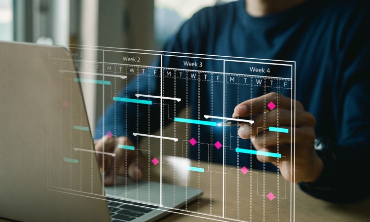 The image shows a person working on a laptop with a transparent digital overlay displaying a project timeline or Gantt chart, illustrating weeks of planned tasks and deadlines.