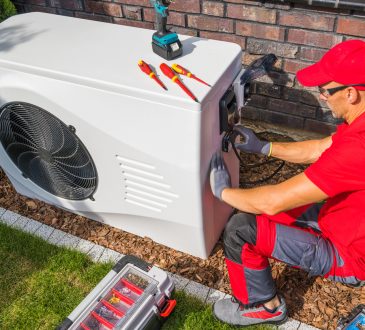 Photo of a HVAC technician fixing an AC.