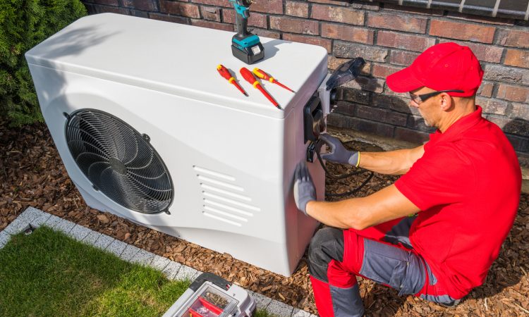 Photo of a HVAC technician fixing an AC.