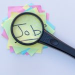 Magnifying glass on top of sticky notes reading "job"