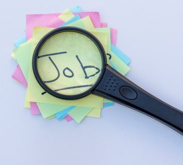 Magnifying glass on top of sticky notes reading "job"