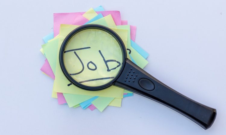 Magnifying glass on top of sticky notes reading "job"