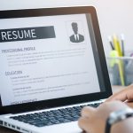 Close up of someone working on a resume on an open laptop.