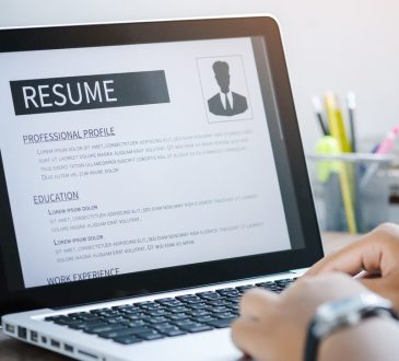 Close up of someone working on a resume on an open laptop.