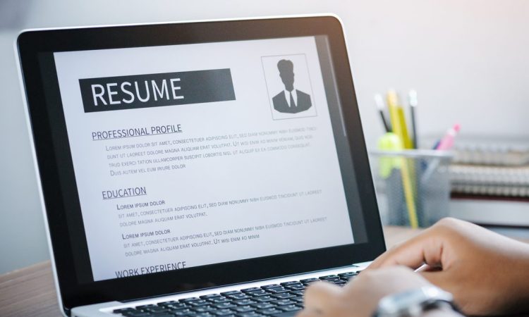 Close up of someone working on a resume on an open laptop.