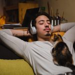 man listening music and laying on sofa at home