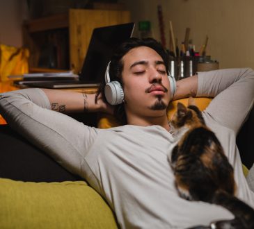 man listening music and laying on sofa at home