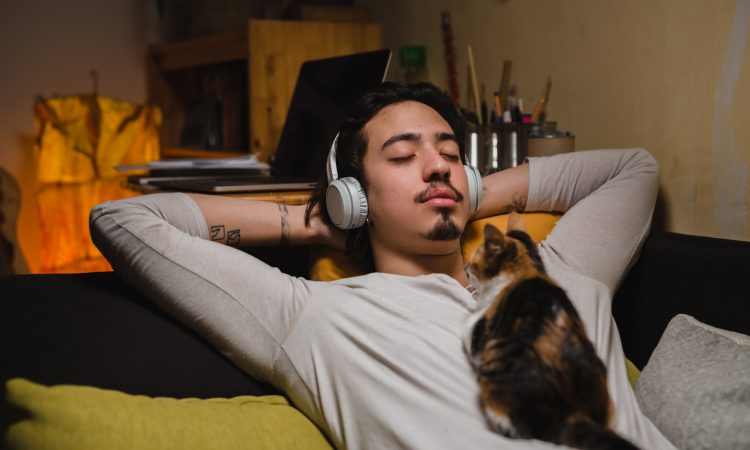 man listening music and laying on sofa at home