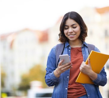 Student messaging on phone walking home after class