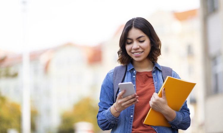 Student messaging on phone walking home after class