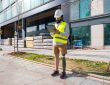Engineer with prosthetic leg working on construction site wearing protective equipment