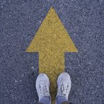 Person standing on arrow on road