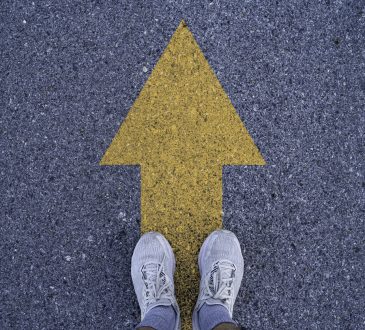 Person standing on arrow on road