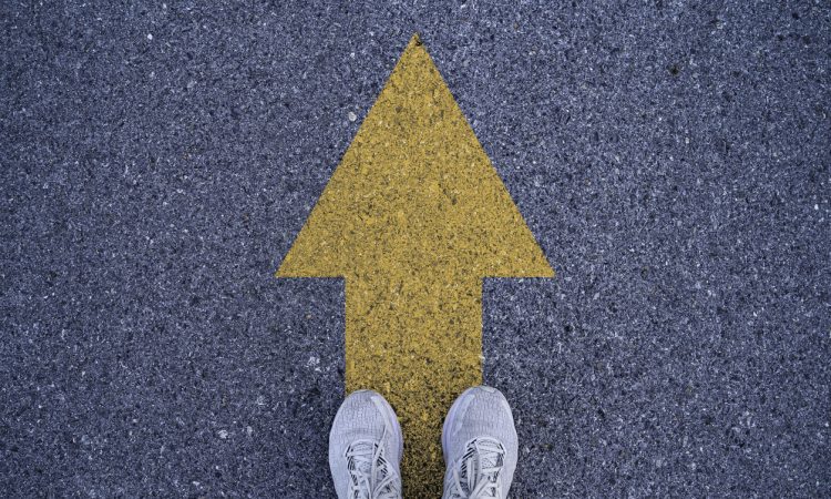 Person standing on arrow on road