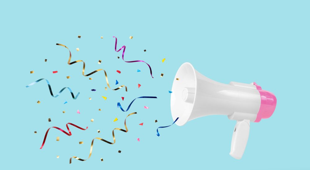 White megaphone with colourful confetti coming out of it