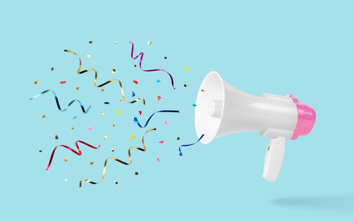 White megaphone with colourful confetti coming out of it