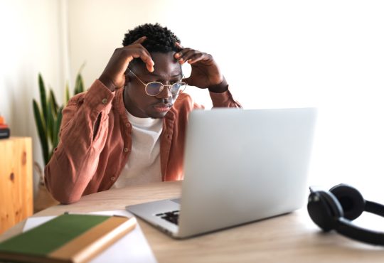 Stressed student sitting at laptop