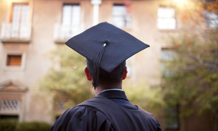 Student wearing graduation cap pictured from behind