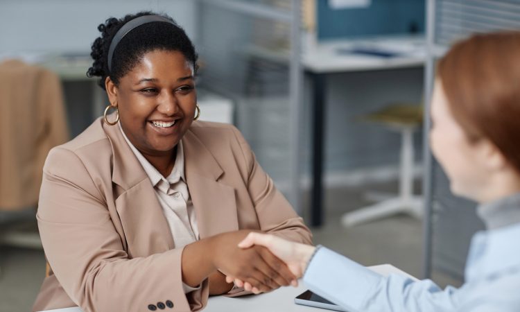 Two people shaking hands in office