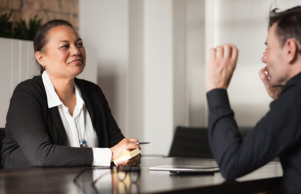 Two people talking across table