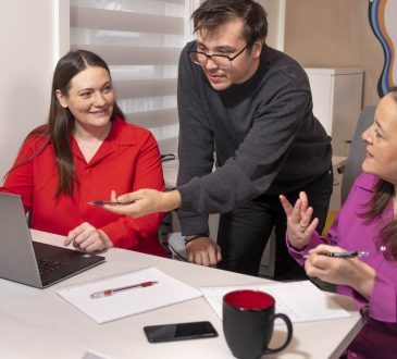 Three people working in computer at office