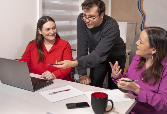 Three people working in computer at office