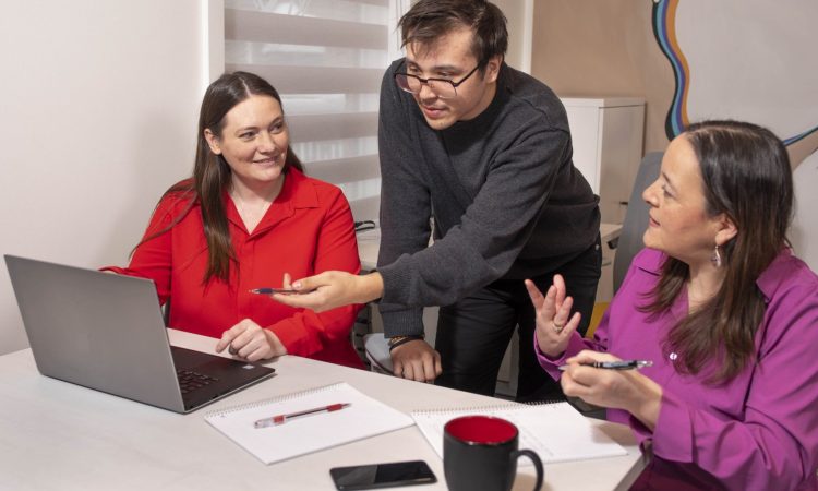 Three people working in computer at office