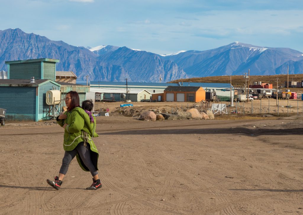 Inuit woman carrying her baby on her back in Pond Inlet, Baffin Island