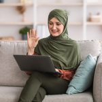 Woman joining video call on laptop on couch