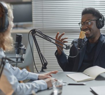 Two people recording podcast with stand mic