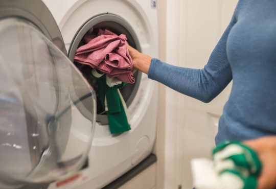 Woman putting clothes in washing machine