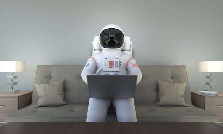 An astronaut working with computer with their suit on.