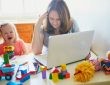 Stressed mom trying to work on computer at home beside screaming child